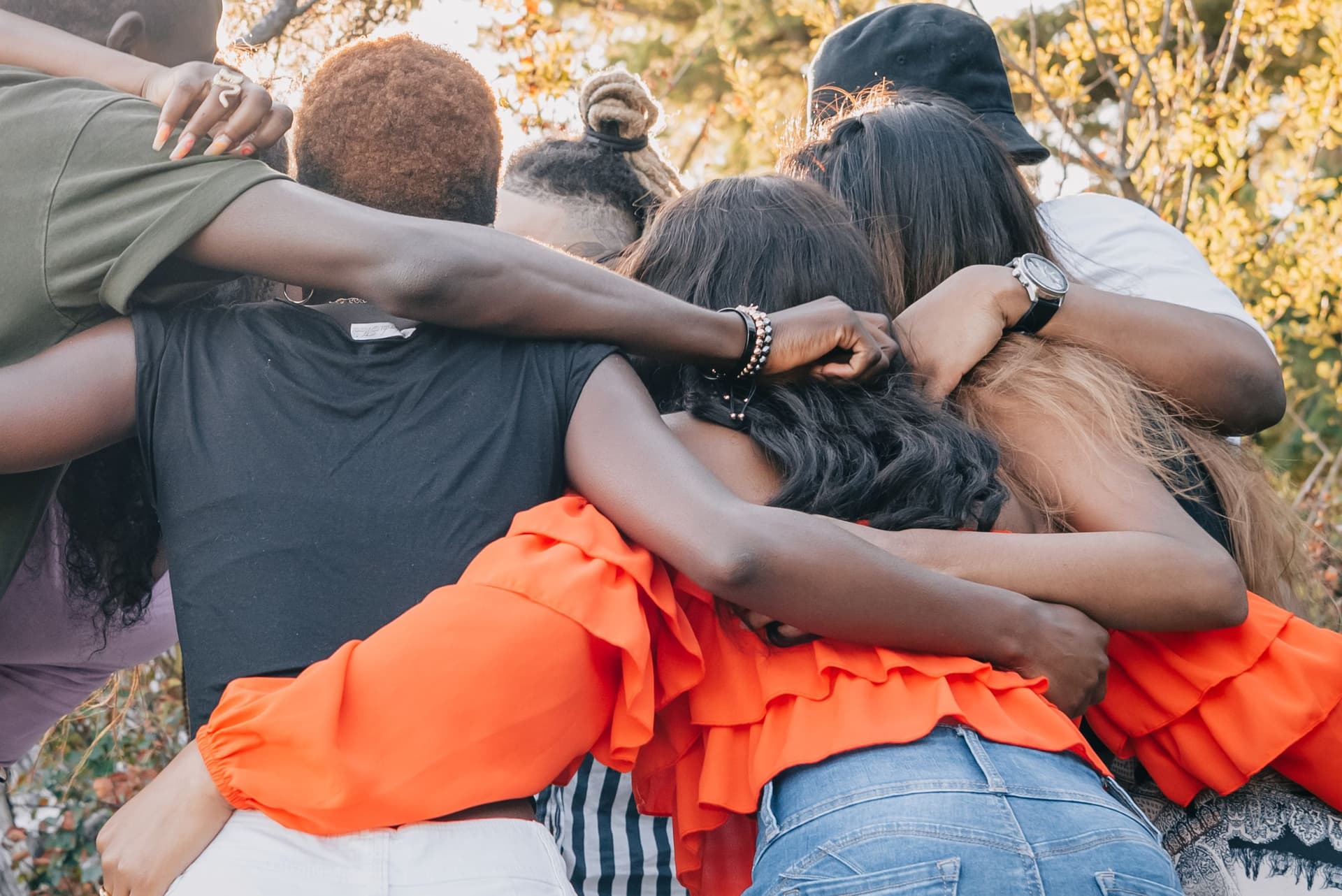 A diverse group of people smiling and supporting one another at a community recovery gathering